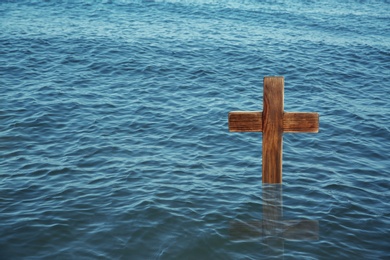 Wooden cross in river for religious ritual known as baptism