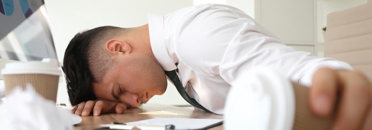 Image of Tired businessman at workplace in office. Banner design
