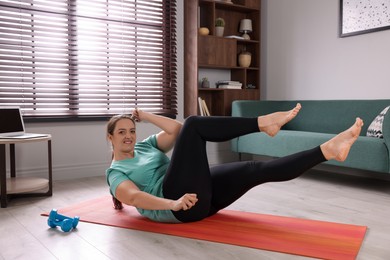Overweight woman doing abs exercise on yoga mat at home