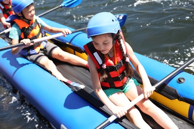Photo of Little children kayaking on river. Summer camp