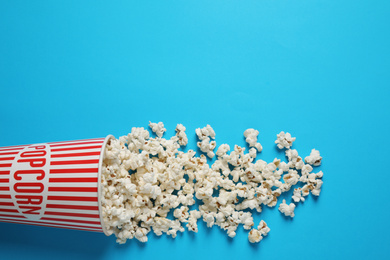 Delicious popcorn on light blue background, top view. Space for text