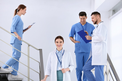 Team of professional doctors on staircase in clinic