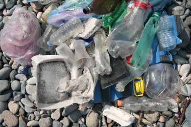 Pile of garbage on stones outdoors, top view. Environmental Pollution concept