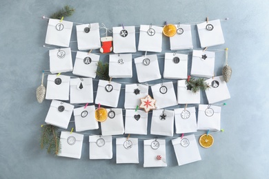 Advent calendar with gifts and Christmas decor hanging on grey wall