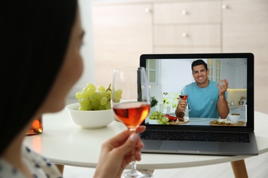Friends drinking wine while communicating through online video conference at home. Social distancing during coronavirus pandemic