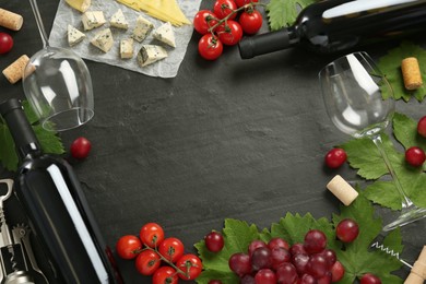 Frame of tasty red wine and snacks on black table, flat lay. Space for text