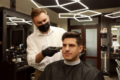 Professional hairdresser making stylish haircut in salon
