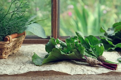 Different fresh green herbs on window sill indoors