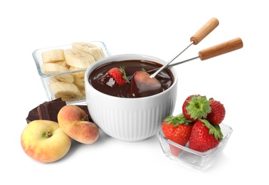 Photo of Fondue forks with strawberries in bowl of melted chocolate and other fruits on white background