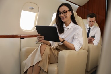 Businesswoman working on tablet in airplane during flight