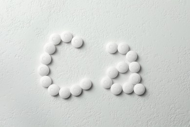 Flat lay composition with calcium supplement pills on white background