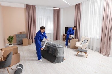 Photo of Male movers with sofa and pillow in new house