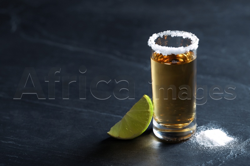 Mexican Tequila shot, lime slice and salt on grey table. Space for text