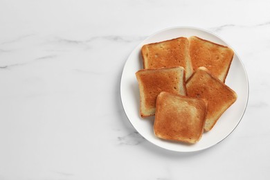 Photo of Slices of tasty toasted bread #on white marble table, top view. Space for text