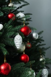 Beautifully decorated Christmas tree on grey background, closeup