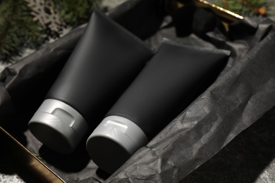 Gift box with men's cosmetic products in black tubes, closeup