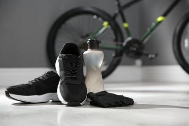 Bicycle gloves, shoes and bottle on floor 