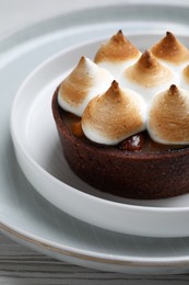 Delicious salted caramel chocolate tart with meringue on white table, closeup