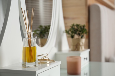 Aromatic reed air freshener and bracelets on dressing table indoors. Space for text