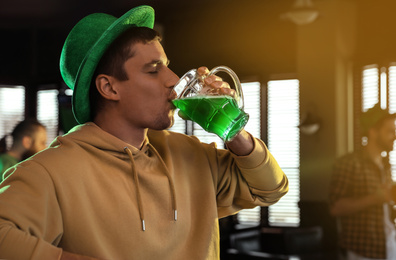 Man drinking green beer in pub. St. Patrick's Day celebration