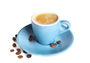 Cup of tasty espresso and scattered coffee beans on white background