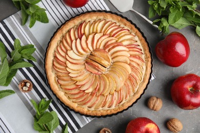 Flat lay composition with delicious homemade apple tart on grey table