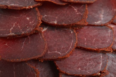 Delicious dry-cured beef basturma slices as background, top view