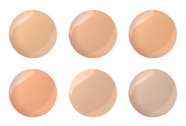 Set with different shades of liquid skin foundation on white background, top view 