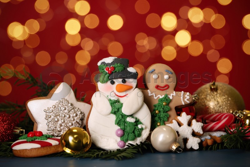 Sweet Christmas cookies and decor on dark table against blurred festive lights