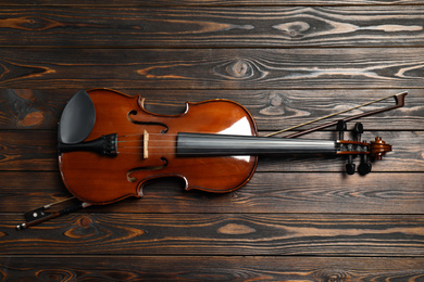 Classic violin and bow on wooden background, top view