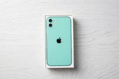 MYKOLAIV, UKRAINE - JULY 10, 2020: New modern Iphone 11 Green in original box on white wooden table, top view