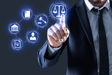 Laws, legal information and online consultation. Man using virtual screen with icons, closeup