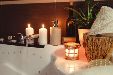 Photo of Bath with burning candles indoors. Creating romantic atmosphere