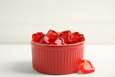 Tasty heart shaped jelly candies on white table
