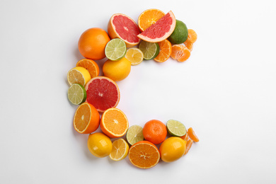 Letter C made with citrus fruits on white background as vitamin representation, top view