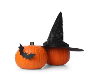 Orange pumpkins with witch hat and black paper bat isolated on white. Halloween decor