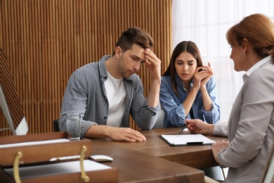 Lawyer having meeting with young couple in office