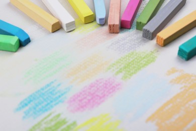 Colorful pastel chalks and scribbles on white background, closeup. Drawing materials