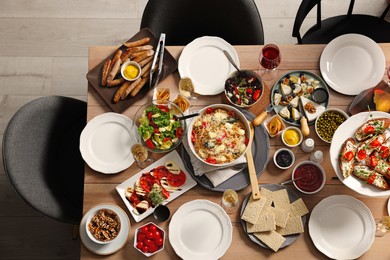 Brunch table setting with different delicious food and chairs indoors, top view