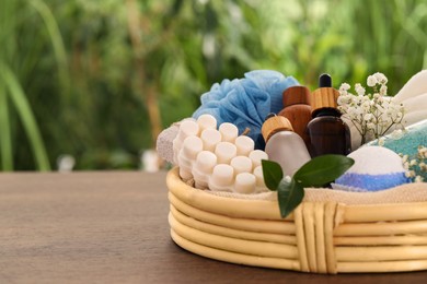 Spa gift set with different products on wooden table against blurred background. Space for text