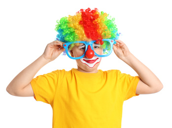 Preteen boy with clown wig and party glasses on white background. April fool's day