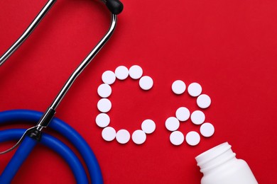 Stethoscope and calcium symbol made of white pills on red background, flat lay