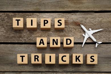 Phrase Tips and Tricks made with cubes on wooden table, flat lay