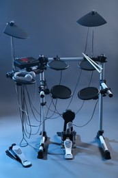 Modern electronic drum kit on grey background, toned in blue. Musical instrument