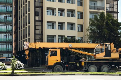 Construction site with crane truck near multistorey building