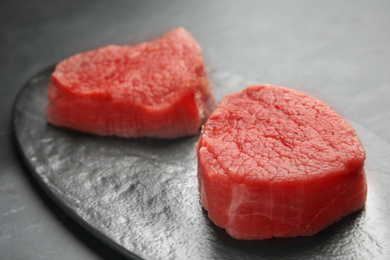 Fresh raw beef cut on black table, closeup