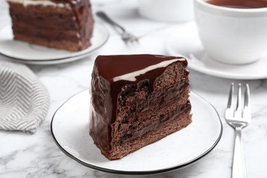 Delicious chocolate cake on white marble table, closeup