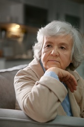 Portrait of elderly woman on sofa at home