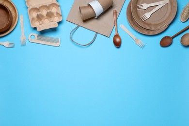 Different eco items on light blue background, flat lay with space for text. Recycling concept