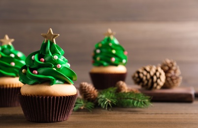 Christmas tree shaped cupcakes on wooden table. Space for text